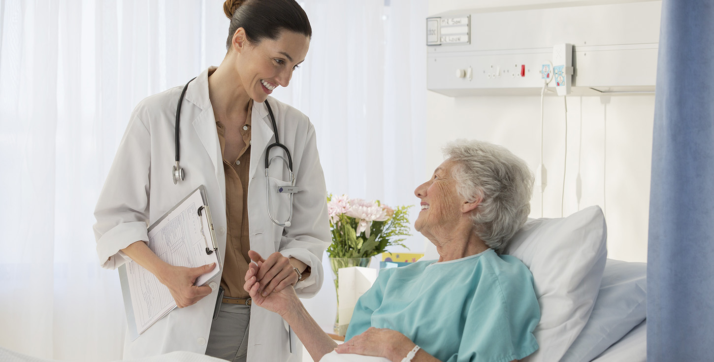 Doctor and senior patient talking in hospital room