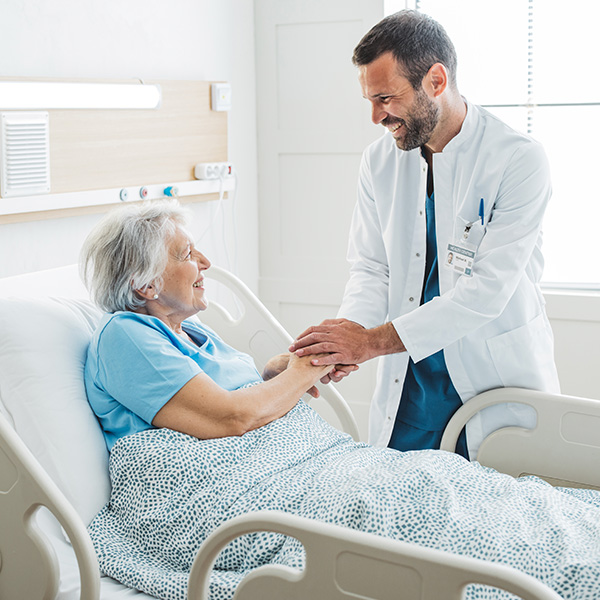 Doctor talking to senior woman in hospital bed-1