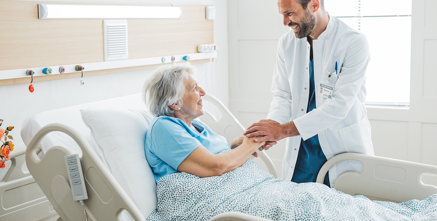 Doctor talking to senior woman in hospital bed-2