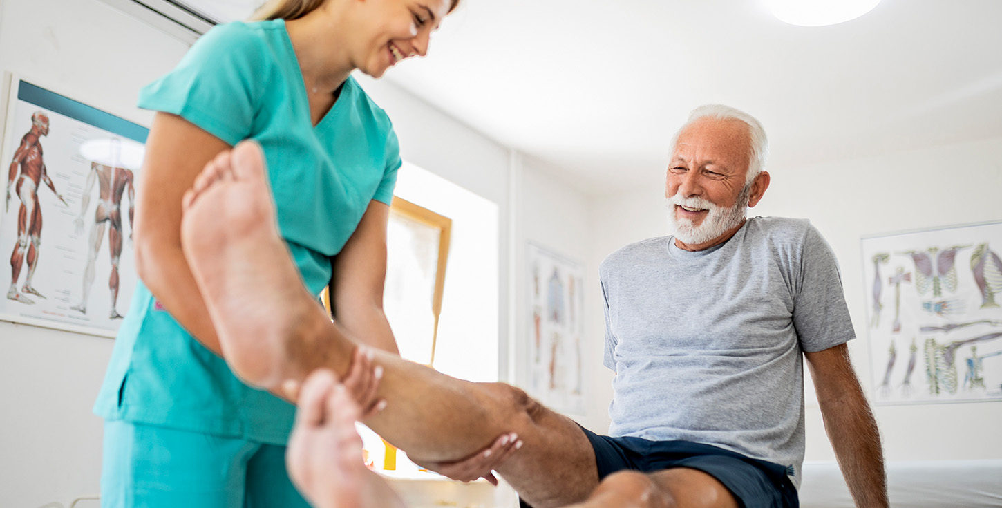 Young smiling physiatrist working with a senior male patient