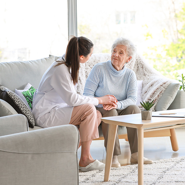 caregiver with sernior woman on couch