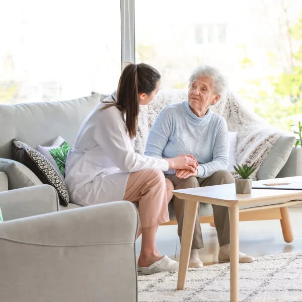 caregiver-talking-with-elderly-woman-on-couch