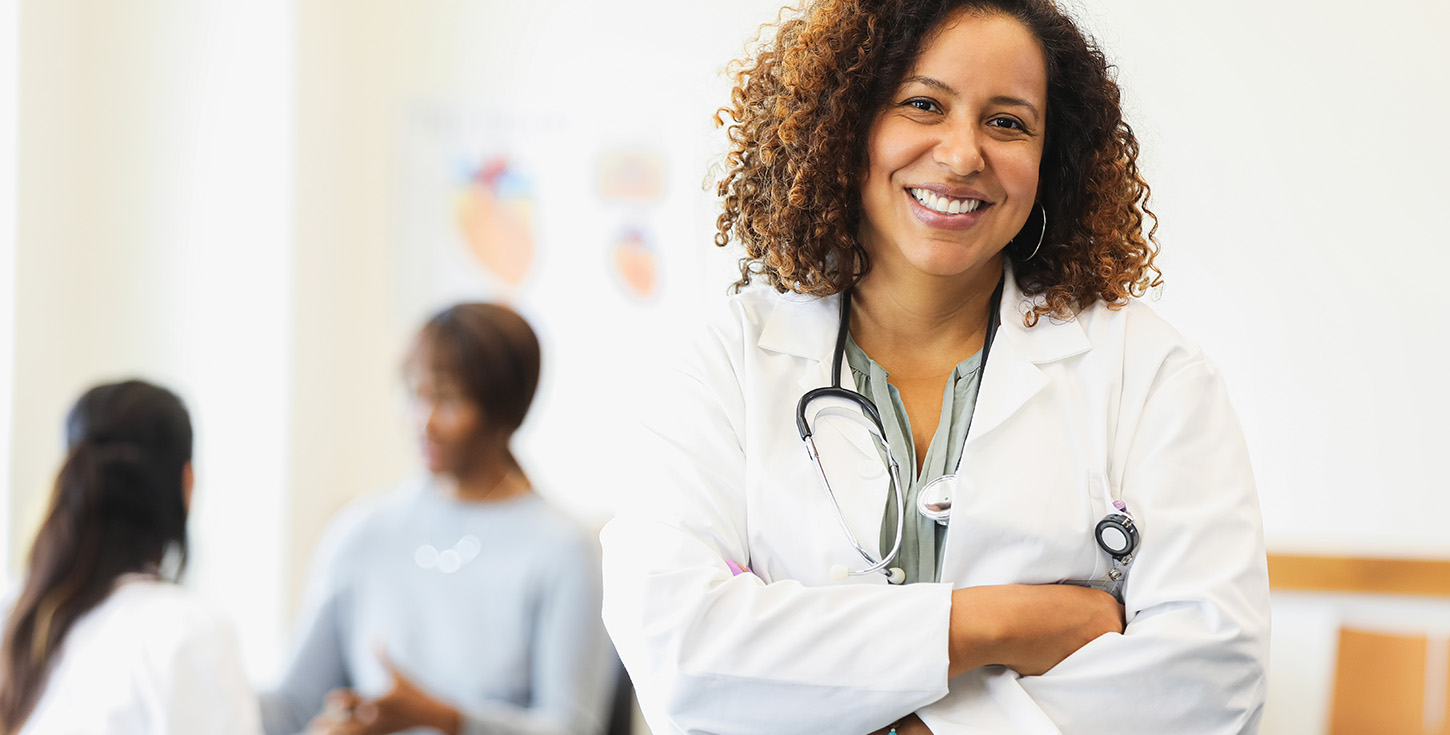 confident female doctor smiles arms crossed