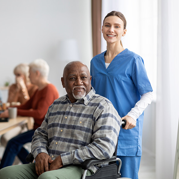 happy nurse helping senior black man wheelchair