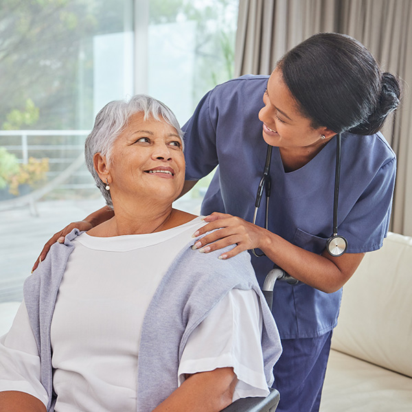 hispanic senior woman in wheelchair and her female nurse_