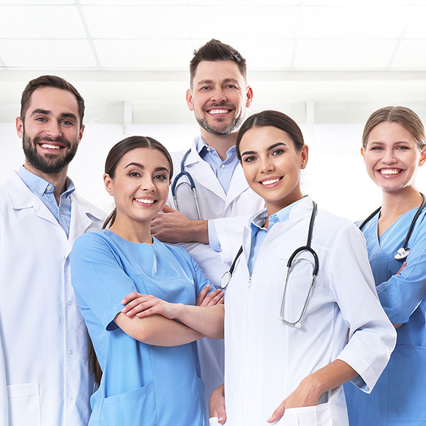 smiling group of five nurses and doctors